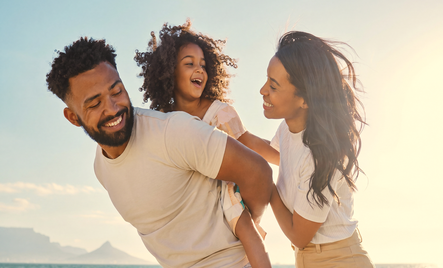 A family playing together on a beach at golden hour